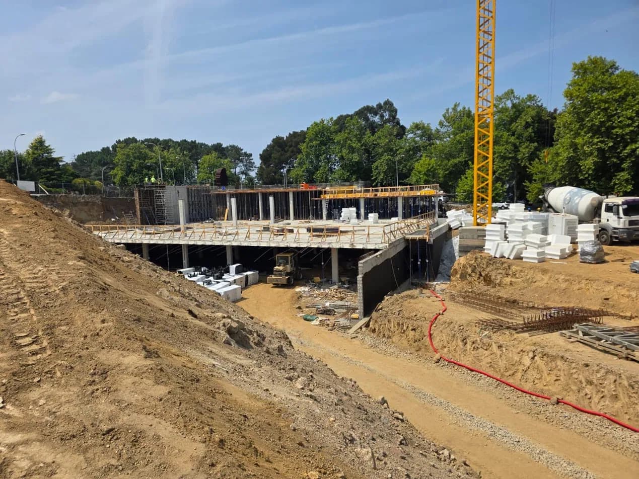 Vista xeral dunha estrutura de formigón armado en construción con grúa torre