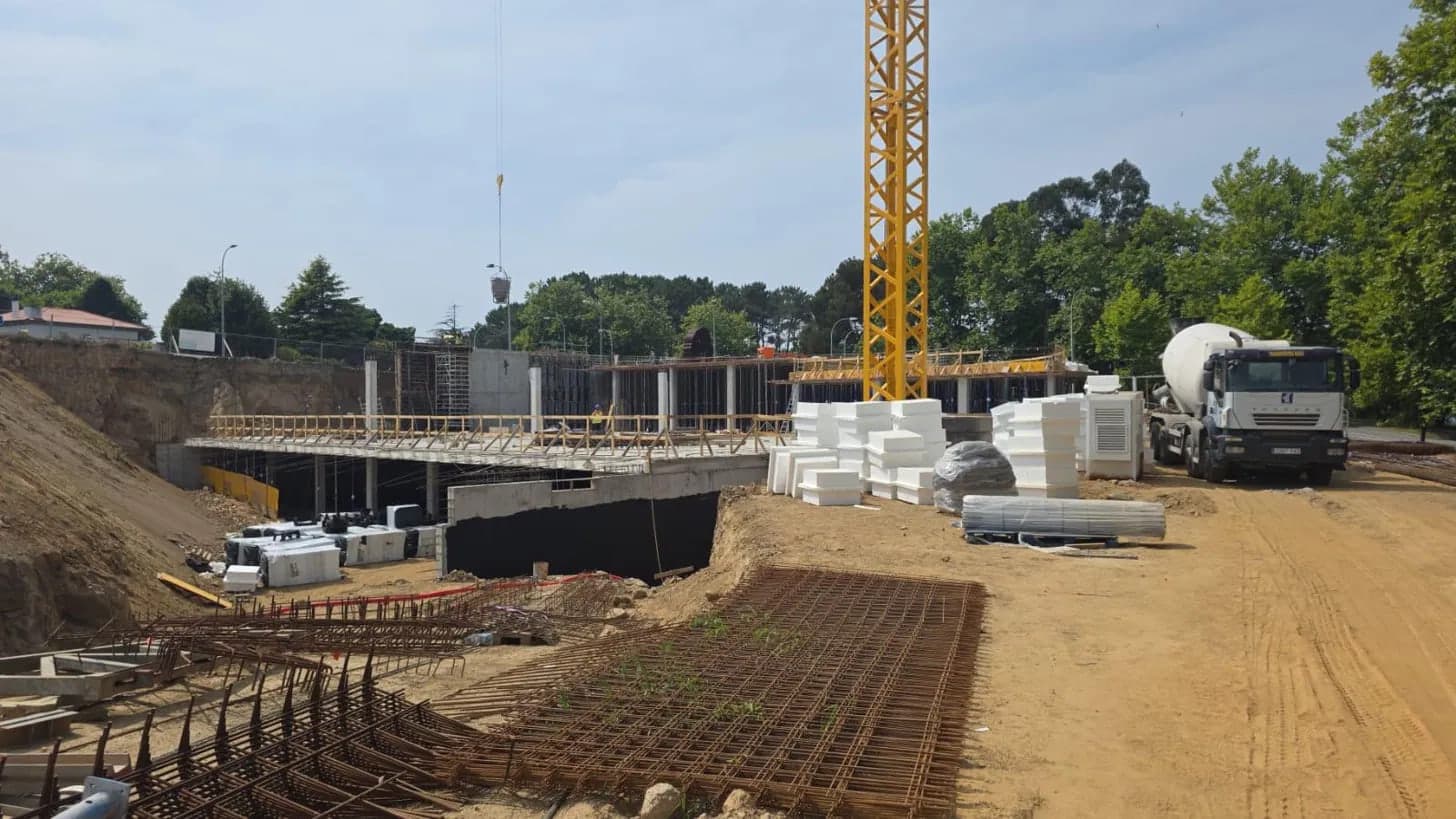 Reinforced concrete structure site with a tower crane, steel mesh and a concrete mixer truck