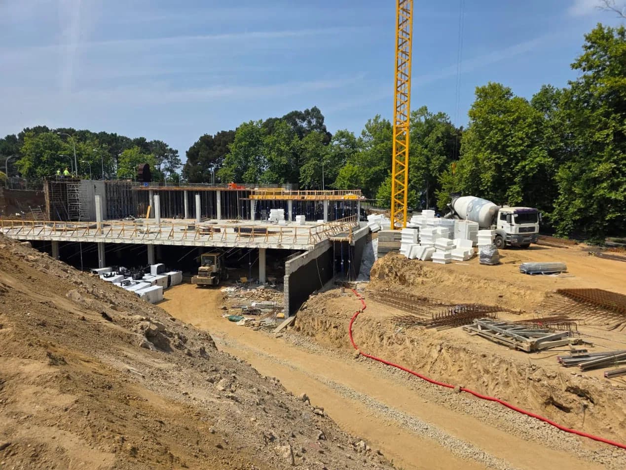 Estructura de hormigón armado con grúa torre y camión hormigonera en obra
